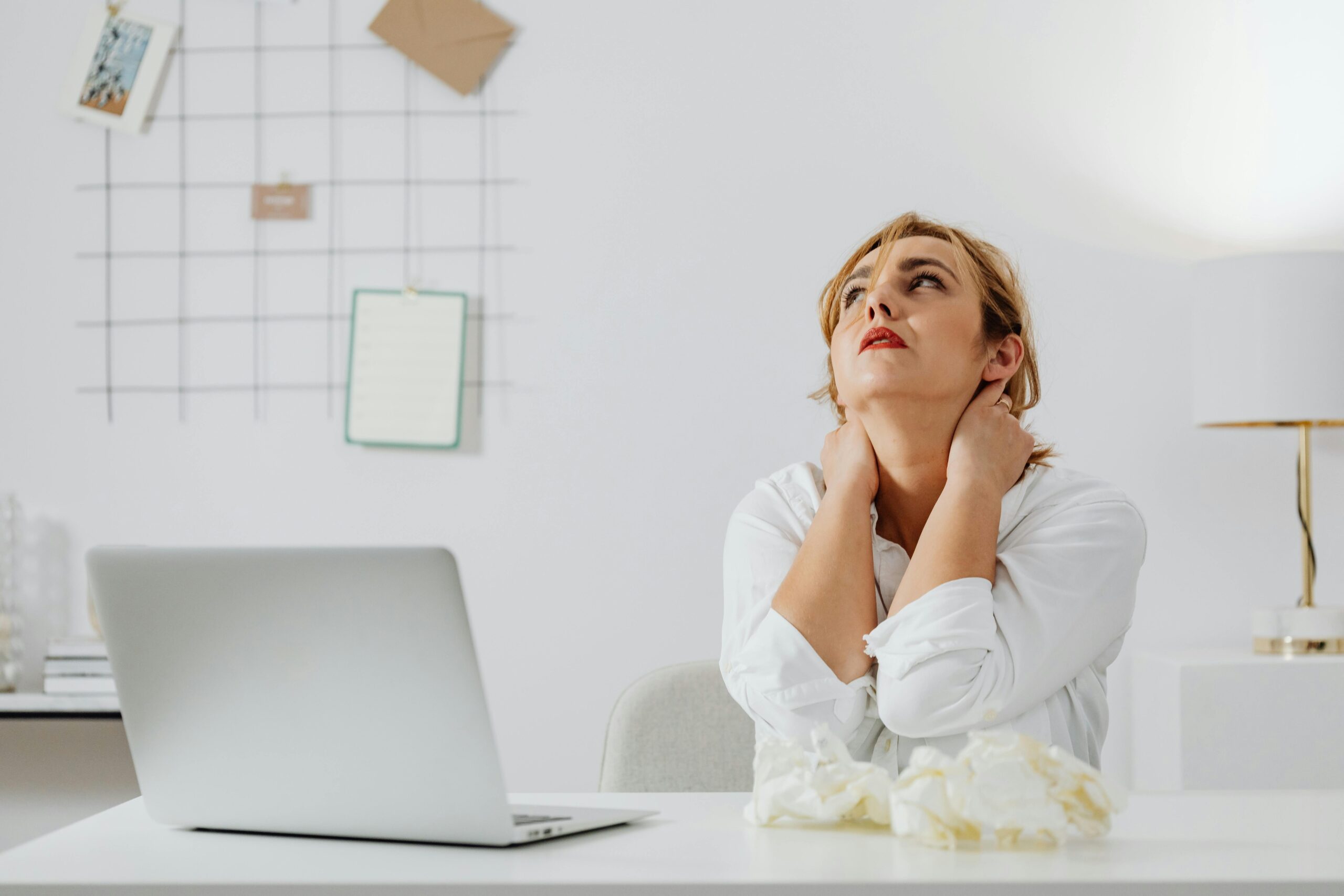 A person looking overwhelmed by their cluttered desk